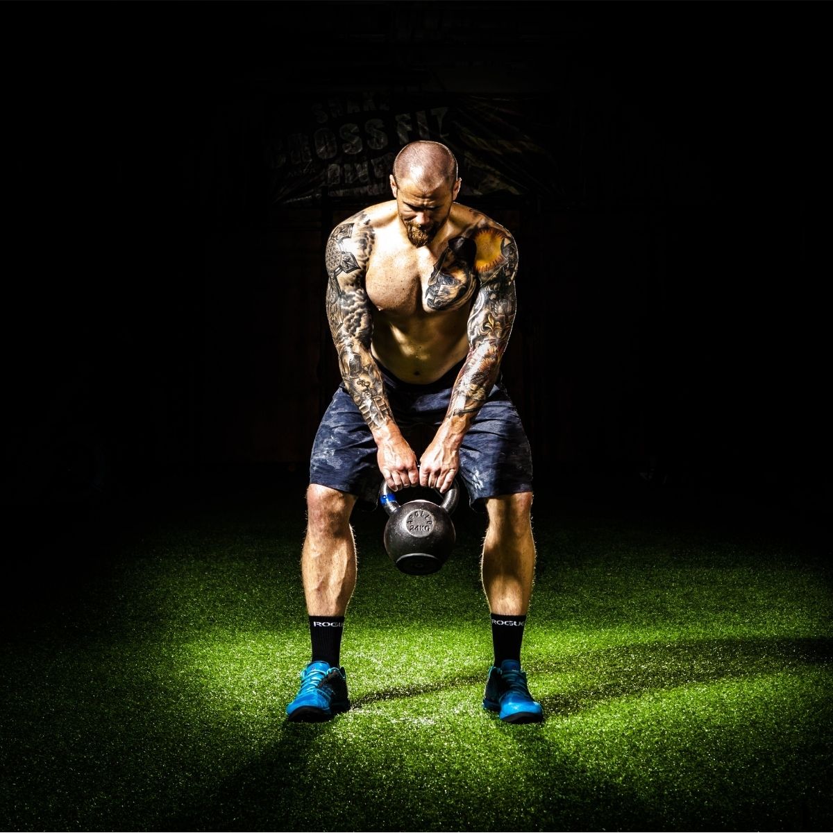 Male fitness enthusiast performing kettlebell squats during leg day at the gym.