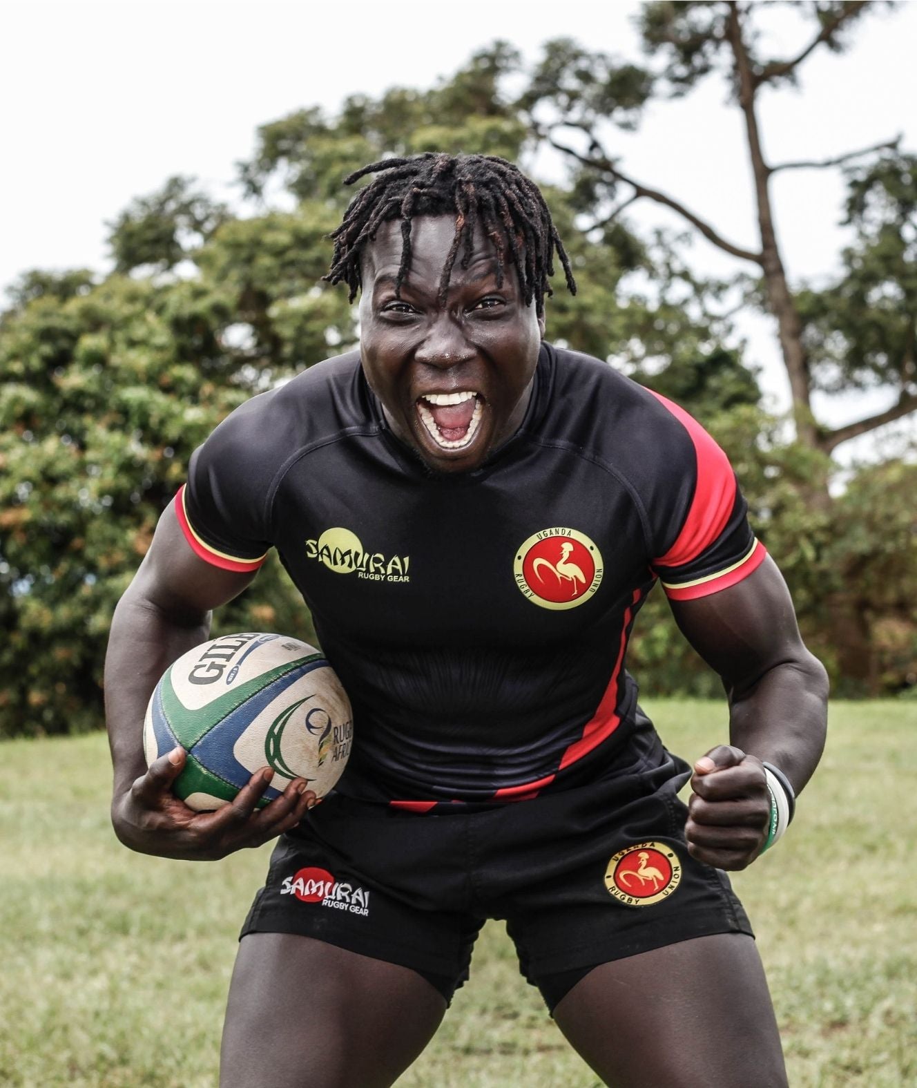 A rugby player with firmly grasping a rugby ball, ready for an intense match.