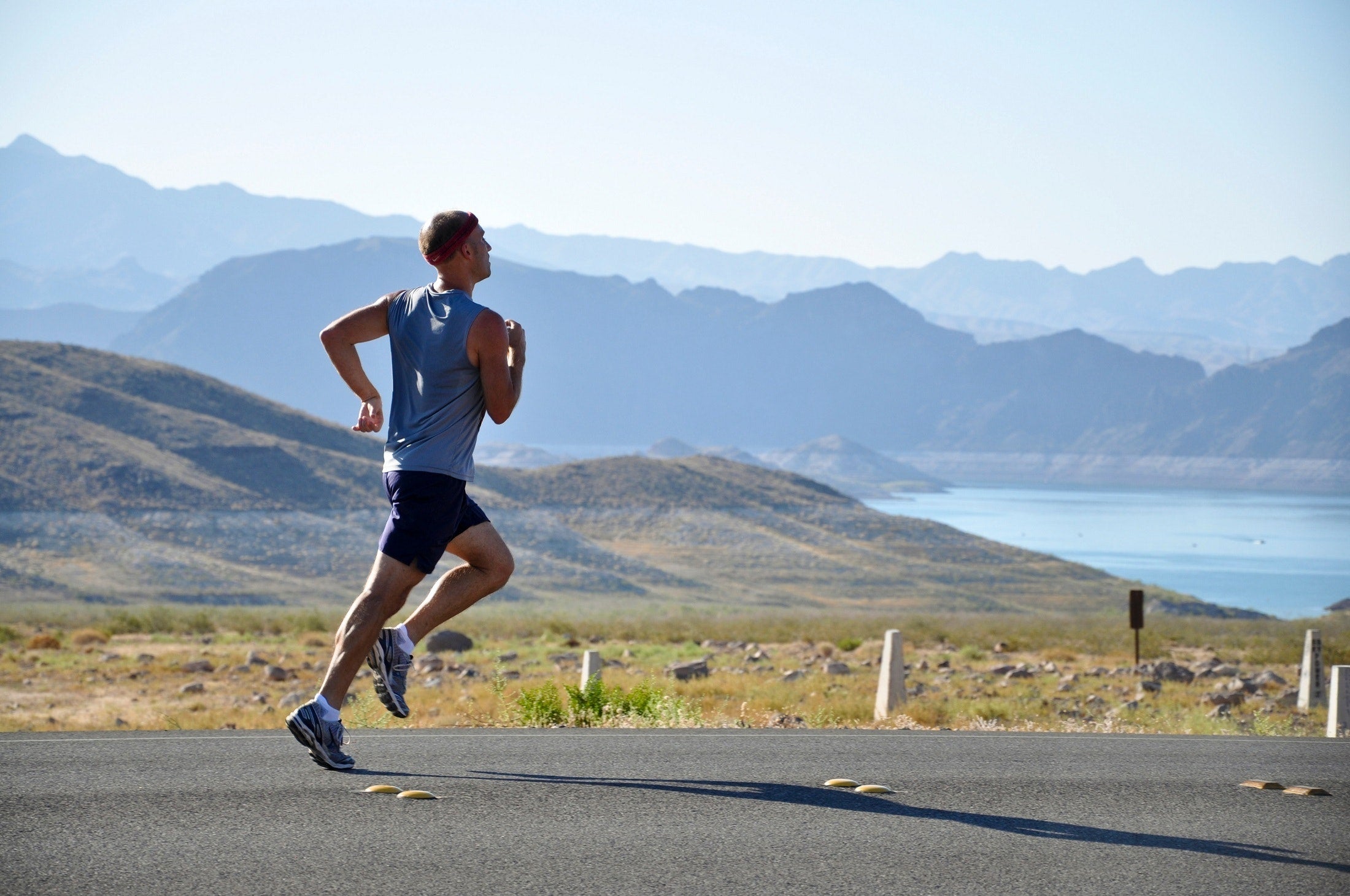 An endurance athlete running along a mountain road